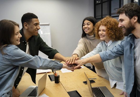 Team members joining hands to celebrate a successful vendor onboarding launch